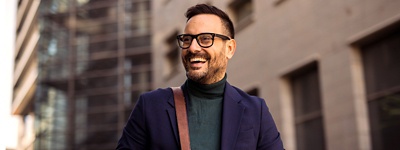 Man with glasses smiling to the side