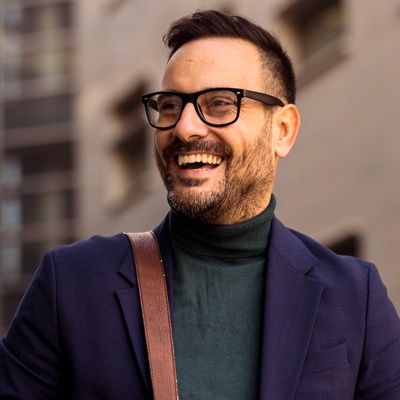 Man with glasses smiling to the side