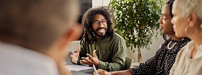 Man with glasses talking to colleagues