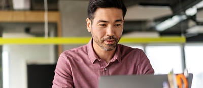 Employee at a desk working on a laptop.