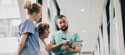 Group of clinicians reviewing information on a tablet together