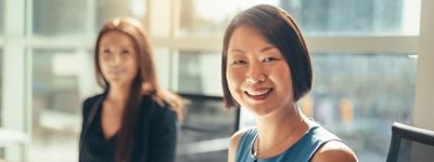 Two people sitting at a conference table in an office.