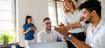 Group of office workers meeting in an open concept workplace.