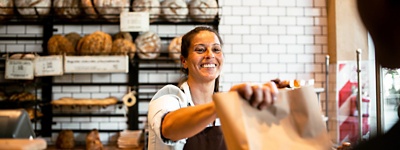 パン屋で接客しながら働く女性。
