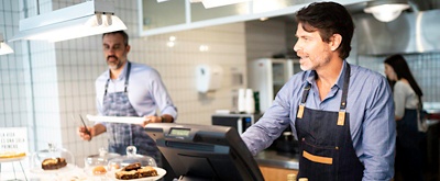 Employees working at the cash register of a quick service restaurant