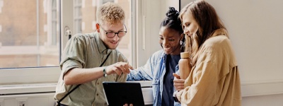 Student showing his colleagues something on laptop