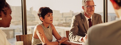 A man in a suit walking outdoors while looking at his phone