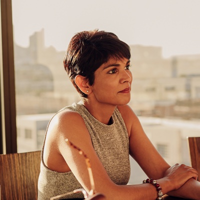 携帯電話を見ながら屋外を歩いているスーツ姿の男性