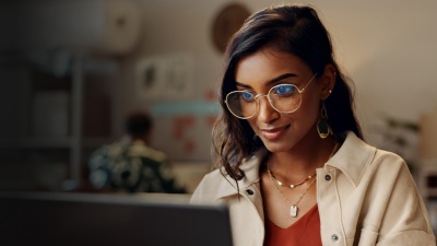 A woman looks intently at something on her computer screen