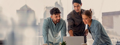 Three people in an office looking at a computer