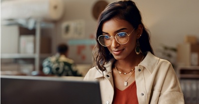 A woman looks intently at something on her computer screen