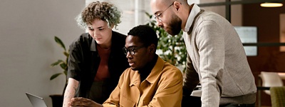 three people looking at laptop