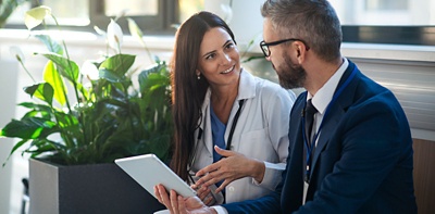 healthcare worker talking to business person 