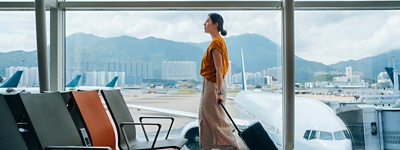 Person in an airport with a suitcase. 