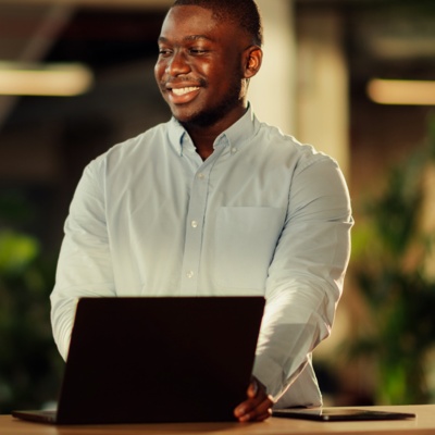 Two coworkers standing smiling up at desk