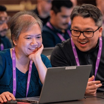 two-people-smiling-at-laptop-devcon-logo-with-gradient