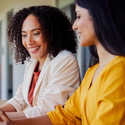 Two women smiling looking at laptop