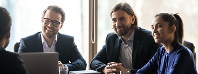 Group of office workers gathered around a conference room table.