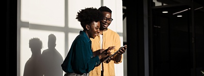 Man and woman smiling looking at a device