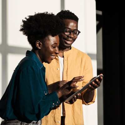 Man and woman smiling looking at a device