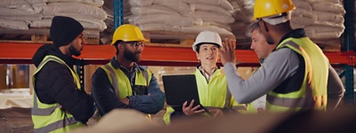Warehouse workers in conversation in warehouse corridor