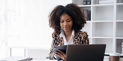 Office worker working on a tablet at a desk.