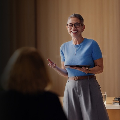 A woman gives a presentation with a tablet to her colleagues