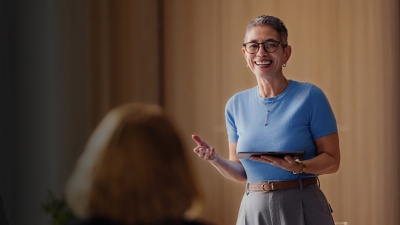 A woman gives a presentation with a tablet to her colleagues
