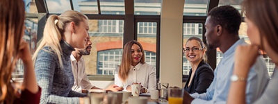 Woman at head of table with group of colleagues