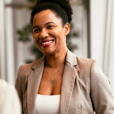 Woman in blazer smiling at person facing her