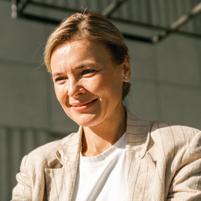 Woman in blazer smiling looking at computer