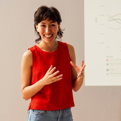 Woman in front of room presenting to colleagues