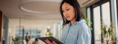 Frau in gestreifter Bluse blickt auf Tablet
