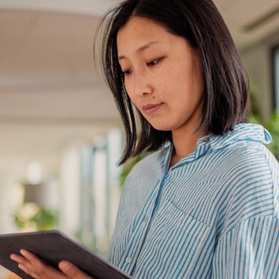 Woman in striped shirt looking at tablet