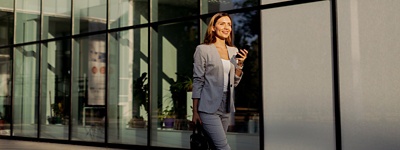 Woman in suit smiling holding phone