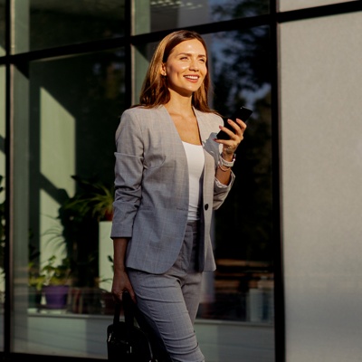 Woman in suit smiling holding phone