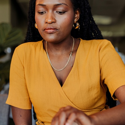Woman in yellow shirt looking down at desk
