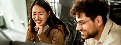 Woman resting head on her hands sitting next to coworker