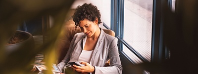 A woman sat in an office looking at her phone