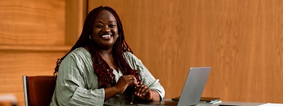 woman smiling at desk on computer