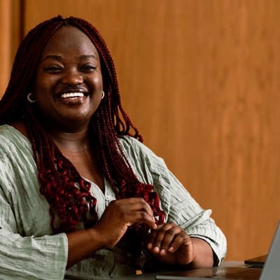 woman smiling at desk on computer