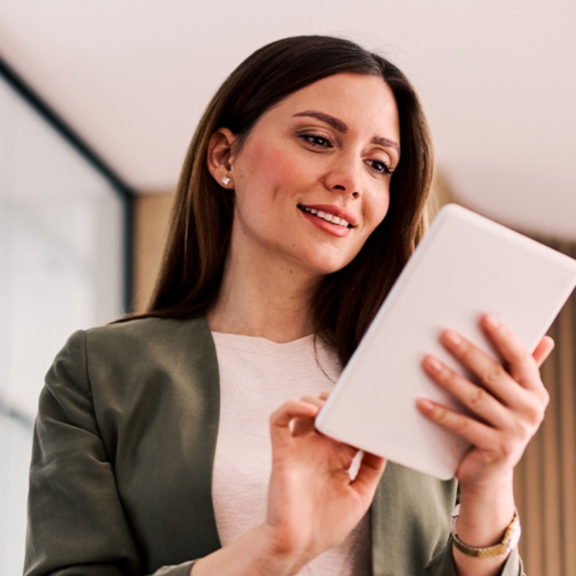 Woman smiling looking down at tablet