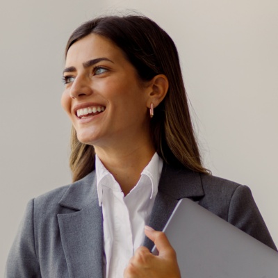 Woman smiling looking in distance holding laptop