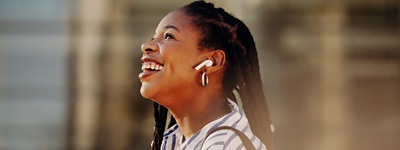 Woman smiling wearing an ear bud