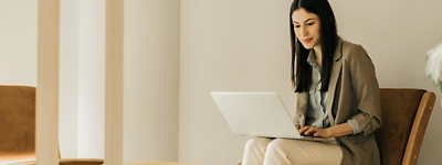 Woman smirking and sitting looking down at laptop