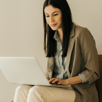 Woman smirking and sitting looking down at laptop