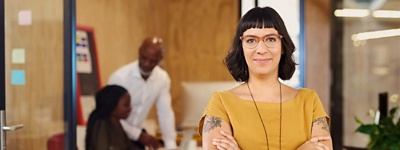 Women with glasses smirking into camera crossing arms