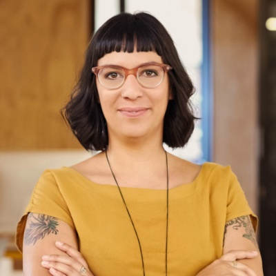 Women with glasses smirking into camera crossing arms