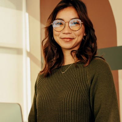 Woman with glasses standing with computer