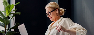 Woman with ponytail looking at laptop